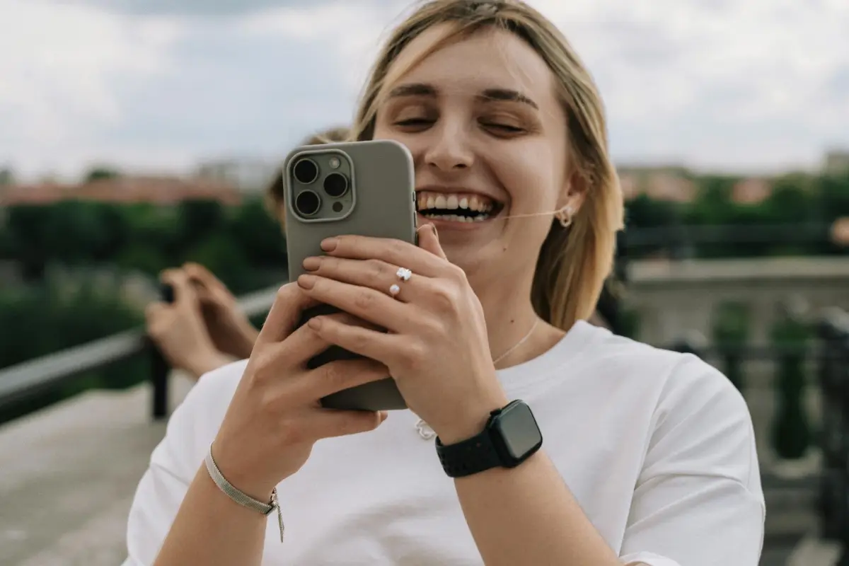 Elégedett ügyfél mosolyog a megjavított telefonjával