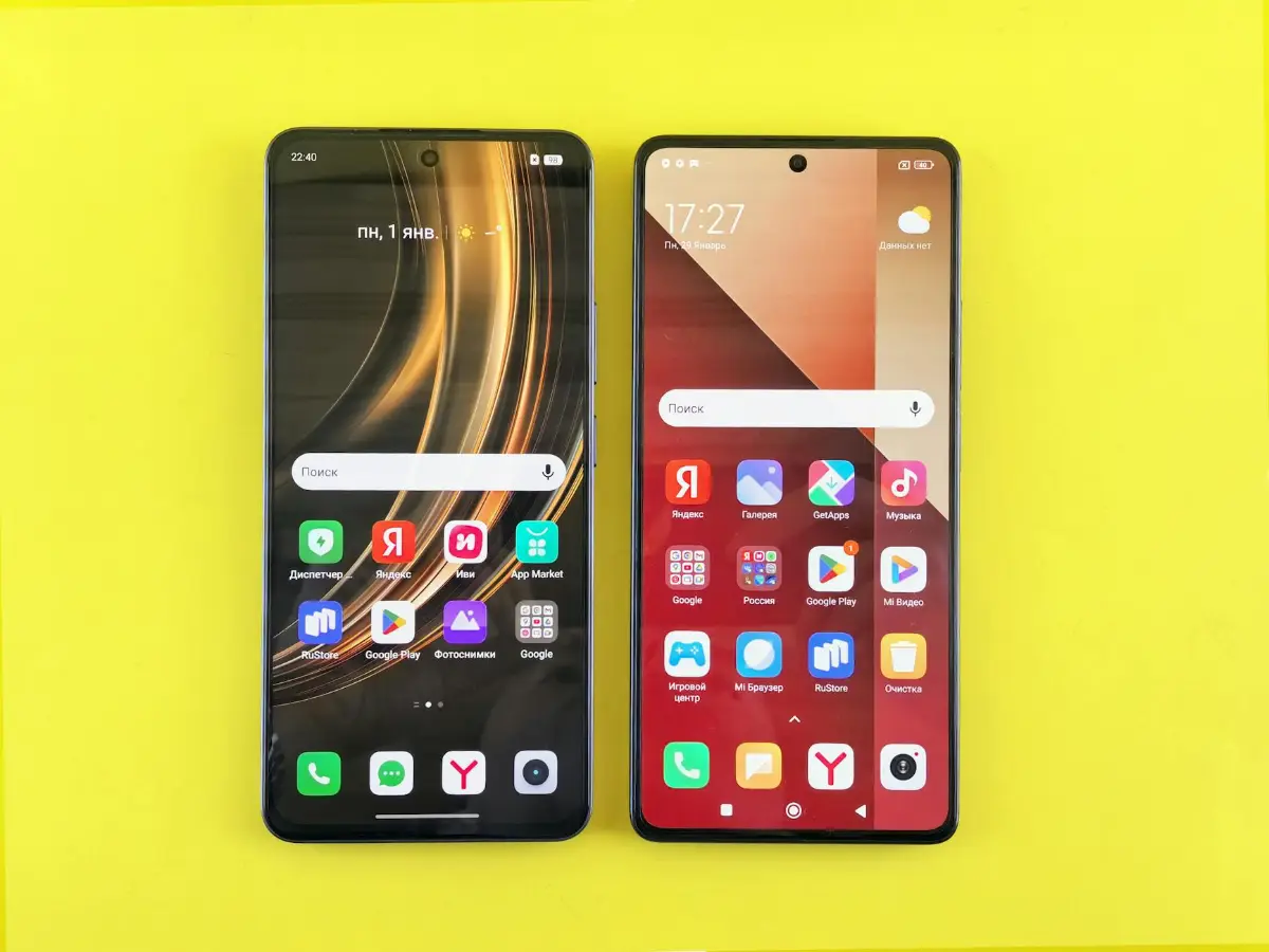 Két androidos okostelefon bekapcsolt kijelzővel sárga háttér előtt